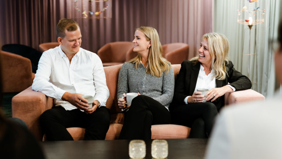 tre personer sitter i en soffa på Accigos kontor